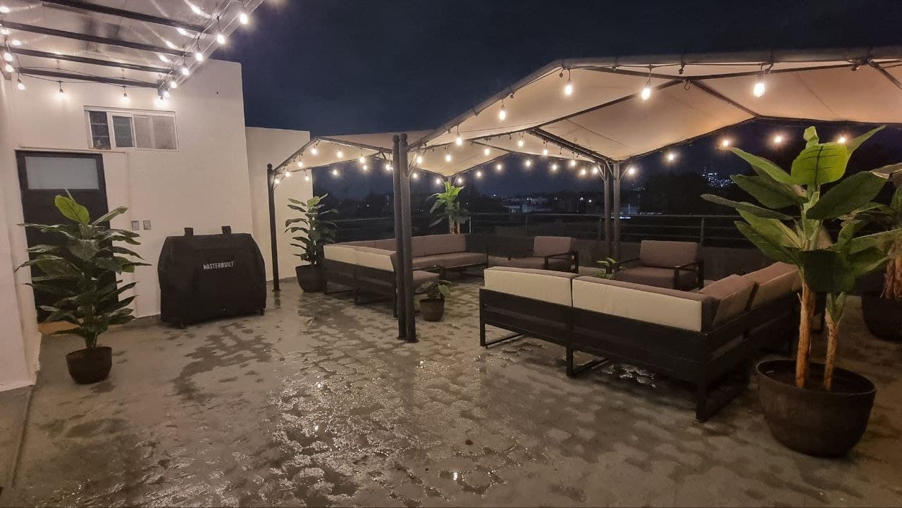 Roof garden techado con sala lounge y luces de noche